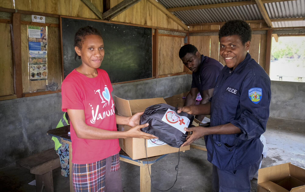 UNFPA Pacific works with local authorities including the Police in disaster preparedness and response.  A 21-year-old police trainee, Annie Dick (right), assisting in the distribution of UNFPA-supported Menstrual Hygiene Management Kits to boarding students at Lamen Bay, Epi Island, after the “Twin Cyclones” Judy and Kevin ravaged the island in March 2023. © UNFPA/David Palazón