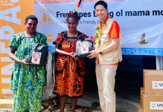 UNFPA Pacific Director, Mr. Iori Kato, handing over the USAID/BHA-supported Menstrual Hygiene Management Kit to community women 