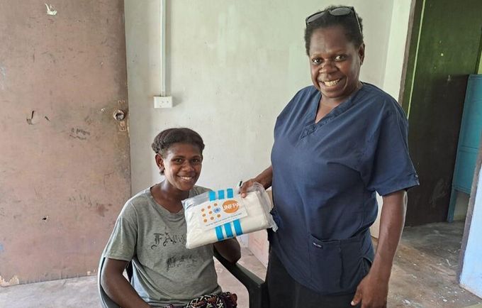 Midwife Elvie Naki hands a ‘Clean Delivery Kit’ to a 24-year-old pregnant woman from Ipota Village on Erromango Island, one of t
