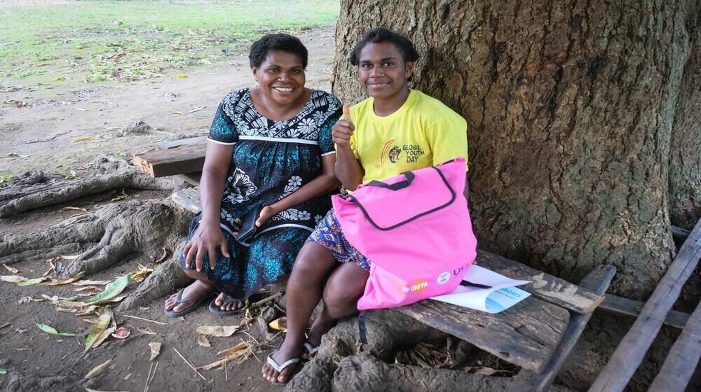 Janet Orah, Area Council Administrator in Epi Island, using sign language, talks to Morasi, a 22-year-old deaf woman from Kuwo.