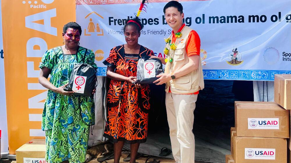 UNFPA Pacific Director, Mr. Iori Kato, handing over the USAID/BHA-supported Menstrual Hygiene Management Kit to community women 